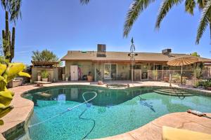 a swimming pool in front of a house at Dreamy Desert Studio with Deck and Pool Access! in Phoenix