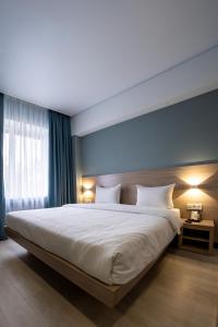 una camera da letto con un grande letto bianco e pareti blu di Resident Hotel Kazybek Bi a Almaty