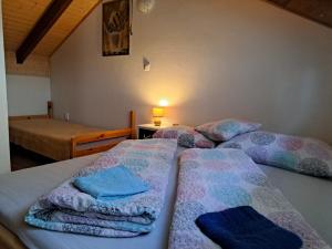 two beds in a room with towels on them at Chata pri Veľkom Kolpašskom tajchu in Banský Studenec