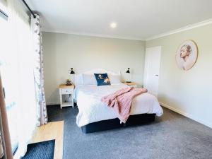 um quarto com uma cama com um cobertor rosa em Alice Garden em Lake Tekapo