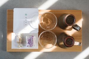 a wooden tray with two cups of coffee on it at Entô in Ama