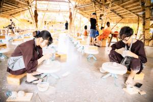Lang's Pá Mé - Homestay - Bungalow - Camping Krông Pắk, Buôn Mê Thuột, Đắk Lắk, Việt Nam في Dak Lak: مجموعة من الناس يعملون على الاثاث في غرفة