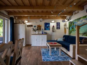 a living room with a blue couch and a table at Chata pri Veľkom Kolpašskom tajchu in Banský Studenec