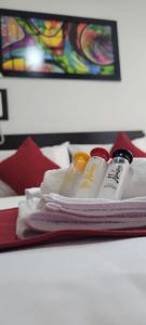 una pila de toallas y crema hidratante sobre una cama en Hotel Naisca 47 en Pasto
