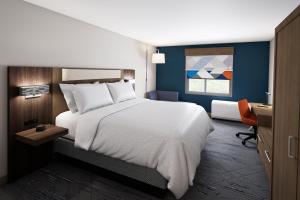 1 dormitorio con 1 cama blanca grande y escritorio en HOLIDAY INN EXPRESS & SUITES DALLAS PLANO NORTH, an IHG Hotel en Plano