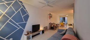 a living room with a couch and a tv at Chambre chez l'habitant cosy et moderne, vue sur montagne in Saint-Denis