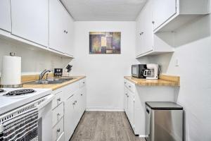 a white kitchen with a sink and a stove at Low-Key Columbus Apartment - Great Location! in Columbus