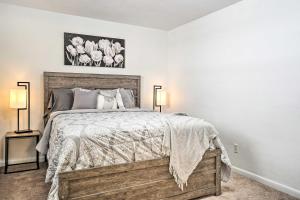 a bedroom with a bed with two lamps and flowers on the wall at Low-Key Columbus Apartment - Great Location! in Columbus