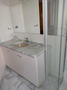 a white bathroom with a sink and a shower at Harringtons102 in Hobart