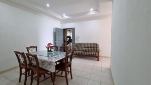 a dining room with a table and chairs and a couch at Kenyalang Emerald Riverine Resort Homestay in Kuching
