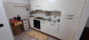 eine kleine Küche mit weißen Schränken und einem Waschbecken in der Unterkunft Casa Nonna Teresinella in Ateleta