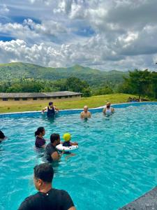 a group of people in a swimming pool at RainTree EcoStay in Māranhalli