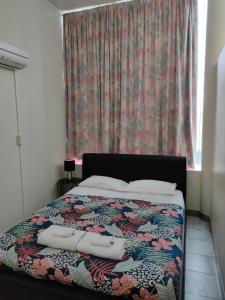 ein Schlafzimmer mit einem Bett mit einer farbenfrohen Tagesdecke und einem Fenster in der Unterkunft Harringtons102 in Hobart