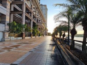 una calle vacía con palmeras delante de un edificio en Kenyalang Emerald Riverine Resort Homestay, en Kuching
