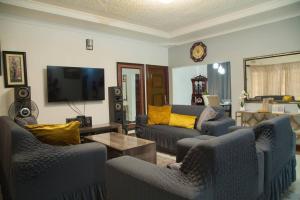 a living room with couches and a flat screen tv at Netflix/WI-FI, 3 bedroom and free parking in Livingstone