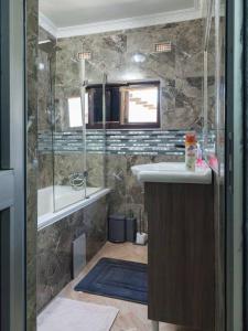 a bathroom with a shower and a sink and a tub at Netflix/WI-FI, 3 bedroom and free parking in Livingstone