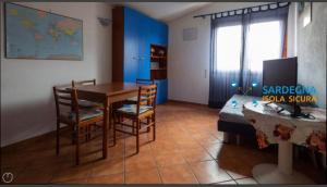 Habitación con mesa, sillas y cama en Airport at 25 min ByWalk-Big Port 10 min by bus-Bus&CommCenter 1 min by walk - 1 min by walk to bus to city and beaches 1 min by walk to touristic port-entire Apartement with 3 indipendent rooms Air cond&WIFI&washMachine till 6 pex AZZURRO en Olbia