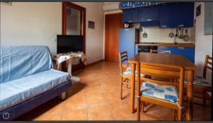 uma cozinha com um sofá e uma mesa numa cozinha em Airport at 25 min ByWalk-Big Port 10 min by bus-Bus&CommCenter 1 min by walk - 1 min by walk to bus to city and beaches 1 min by walk to touristic port-entire Apartement with 3 indipendent rooms Air cond&WIFI&washMachine till 6 pex AZZURRO em Olbia