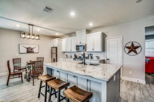 a kitchen with white cabinets and a counter with stools at Western Wonder in Arlington
