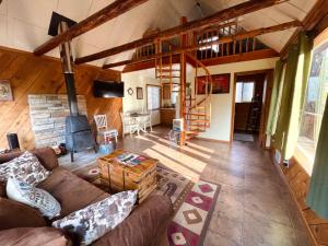 Mt Rainier Little Red Cabin في أشفورد: غرفة معيشة مع أريكة ومدفأة