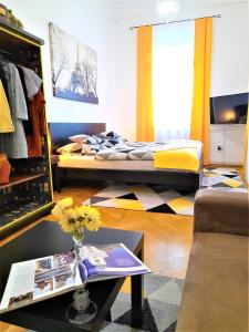 uma sala de estar com duas camas e uma mesa em D16 Apartman em Szentgotthárd