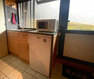 een keuken met een magnetron en een koelkast bij Studio 2 pers Piau Engaly Le Gypaète résidence Moudang I in Aragnouet