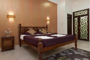 a bedroom with a large bed with purple sheets at Lavish Executive Villa with Private Swimming Pool in Calangute