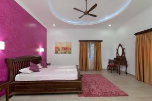 a bedroom with a bed and a table and a ceiling at Lavish Executive Villa with Private Swimming Pool in Calangute