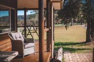 a porch with a chair and a view of a field at Cooranbong Farm Stay-7 Bedrooms Cottage with Pool and Tennis Court in Cooranbong