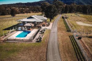 an aerial view of a house with a swimming pool and a road at Cooranbong Farm Stay-7 Bedrooms Cottage with Pool and Tennis Court in Cooranbong