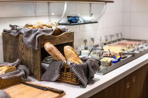 a kitchen counter with baskets of bread and a stove at Comfort Hotel Linköping City in Linköping