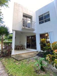 Dieses weiße Haus verfügt über einen Balkon und einen Tisch. in der Unterkunft Residencial Bali Casa Mariposa in Playa del Carmen