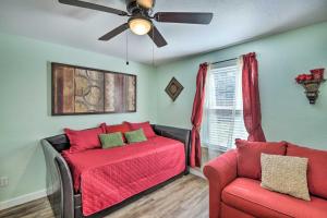 una camera con letto, divano e ventilatore a soffitto di 1 Mi to UTA Arlington Elm Cottage with Fenced Yard ad Arlington