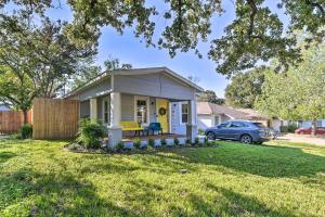 una piccola casa in un cortile con una macchina di 1 Mi to UTA Arlington Elm Cottage with Fenced Yard ad Arlington