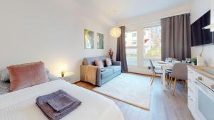 a bedroom with a bed and a dining room at Bellarova Apartments Lehtikatu in Rovaniemi