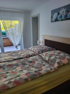 a bedroom with a bed with a quilt on it at Gästewohnung 1 in Oschersleben