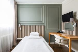 a bedroom with a bed and a desk and a computer at Comfort Hotel Linköping City in Linköping