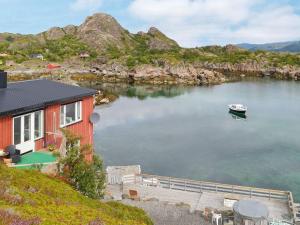 a boat in the water next to a house at Two-Bedroom Holiday home in Gravdal 1 in Gravdal
