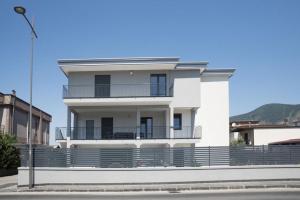 a white house with a balcony on a street at Studio Apartment Angelo - free private parking in Sarno