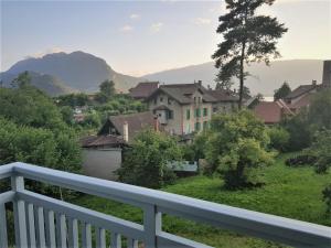 uma varanda com vista para uma cidade com montanhas em Talloires Village, Lac d'Annecy, Résidence récente 4 étoiles em Talloires