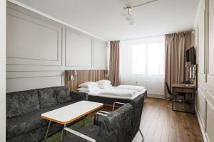 Comfort Hotel Linköping City في لينكوبِنغ: غرفة معيشة مع أريكة وسرير