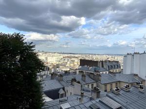 uitzicht op de stad vanaf de daken van gebouwen bij Spacieux appartement à 50m du Sacre Coeur - Magnifique Vue in Parijs