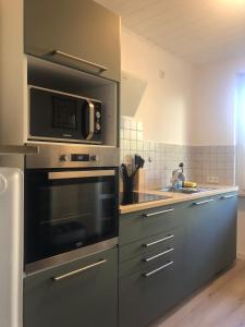 a kitchen with stainless steel appliances and a microwave at Ferienwohnung in der Sanderau in Würzburg