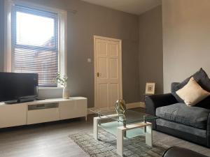 a living room with a couch and a tv at Alexander Apartments Gateshead 2 in Gateshead