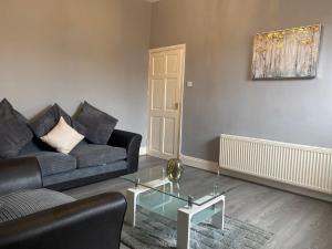 a living room with a couch and a glass table at Alexander Apartments Gateshead 2 in Gateshead