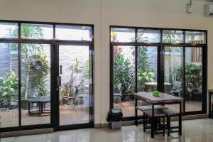 Habitación con puertas correderas de cristal, mesa y sillas. en Residence 6 en Yakarta