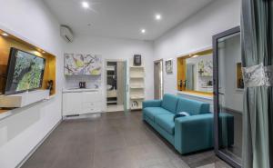 a living room with a blue couch and a tv at Villa Martinis in Rogoznica