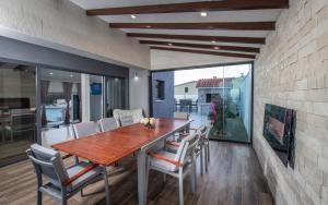 a dining room with a wooden table and chairs at Villa Martinis in Rogoznica