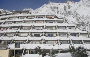 un edificio cubierto de nieve con una montaña en el fondo en Appart 5 pers Piau Engaly L Izard La Géla pistes à 50M, en Aragnouet