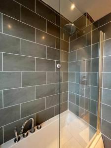 a bathroom with a shower and a bath tub at Homestay near Roundhay Park, North Leeds in Leeds